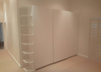 custom built in cupboards with gloss white sliding doors