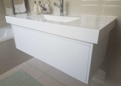 custom suspended vanity cupboard with countertop and sink and no handles on door