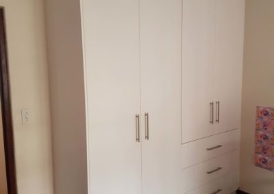 White bedroom built in cupboards with hanging space and draws on the side 4