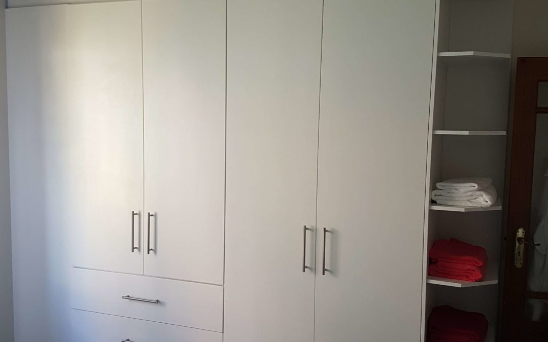 white built in cupboards from floor to ceiling with hanging space and draws