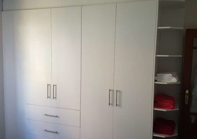 white built in cupboards from floor to ceiling with hanging space and draws