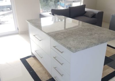 white kitchen cupboards on kitchen island with grey counters
