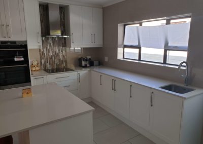 bespoke kitchen built out with white panel doors with a custom tile work 2