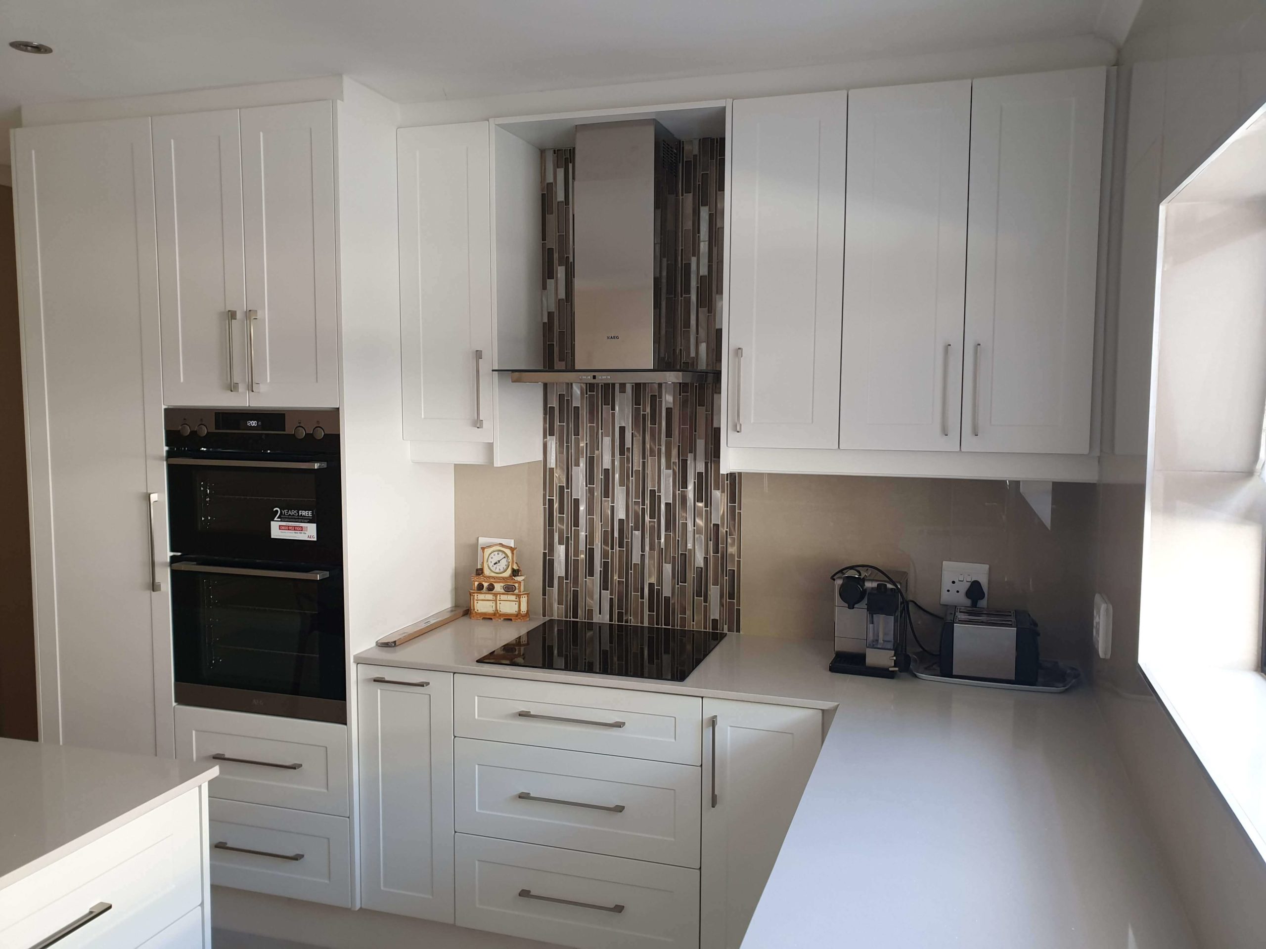 bespoke kitchen built out with white panel doors with a custom tile work