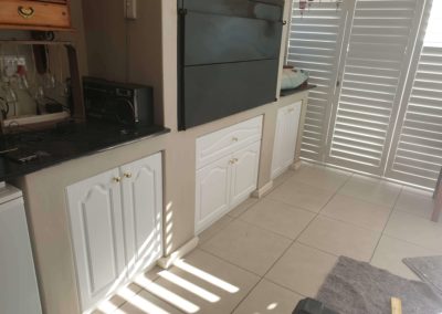 Custom braai/ BBQ cupboards installed with white doors and edging