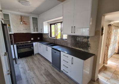 white kitchen installation with dark grey counters and bespoke satin grey sink and faucet 3