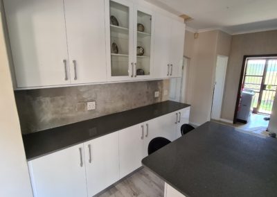 White cupboards with dark grey counters built and installed by bespoke designs