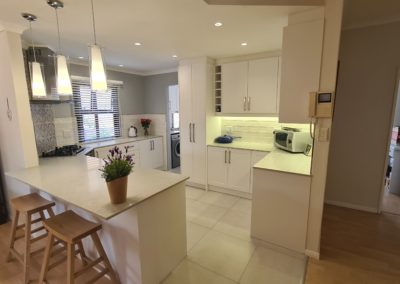 beautiful kitchen installation by Bespoke designs featuring white cupboard doors and light coloured countertops 9