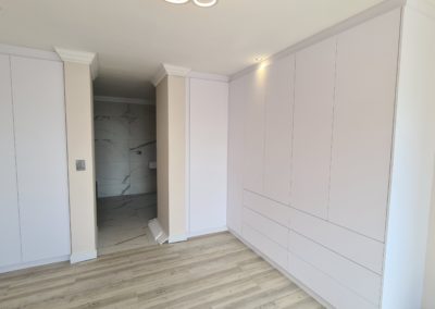 White built in cupboards floor to ceiling with no handles