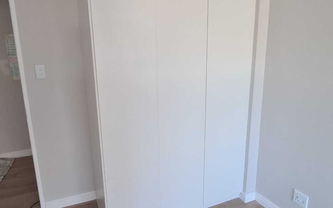 white built in cupboards from floor to ceiling in gloss white and no handles