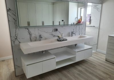 custom white vanity suspended under the basin sink with doors and table tops in gloss white 2