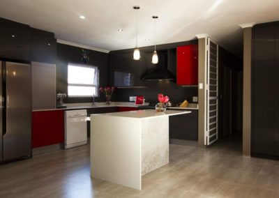 custom built kitchen with black and red cupboards doors with white kitchen countertops 2