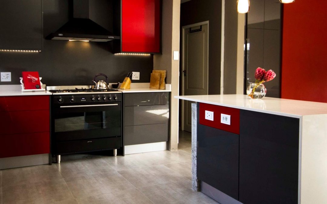 custom built kitchen with black and red cupboards doors with white kitchen countertops