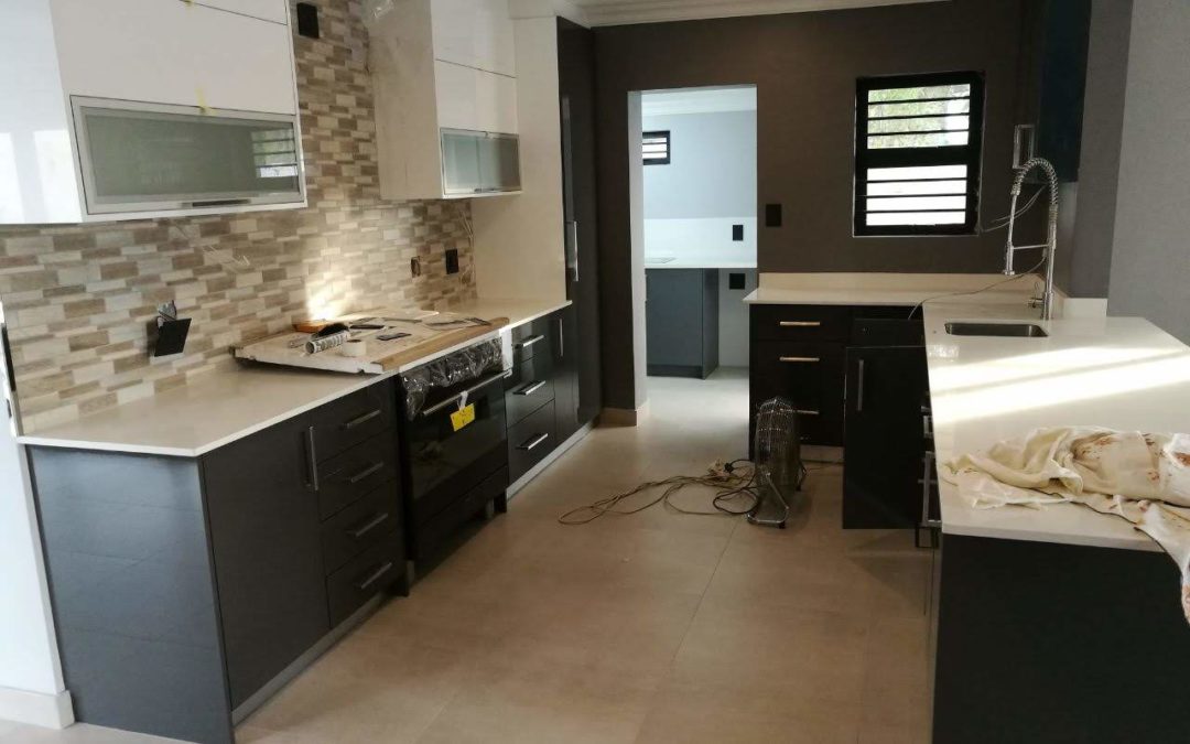 Bespoke designs kitchen renovation with dark doors and white countertops 2